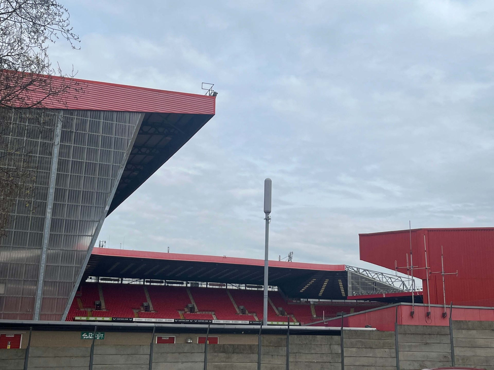 Uitkragend rood dak van een tribune van The Valley met zicht op de overkant