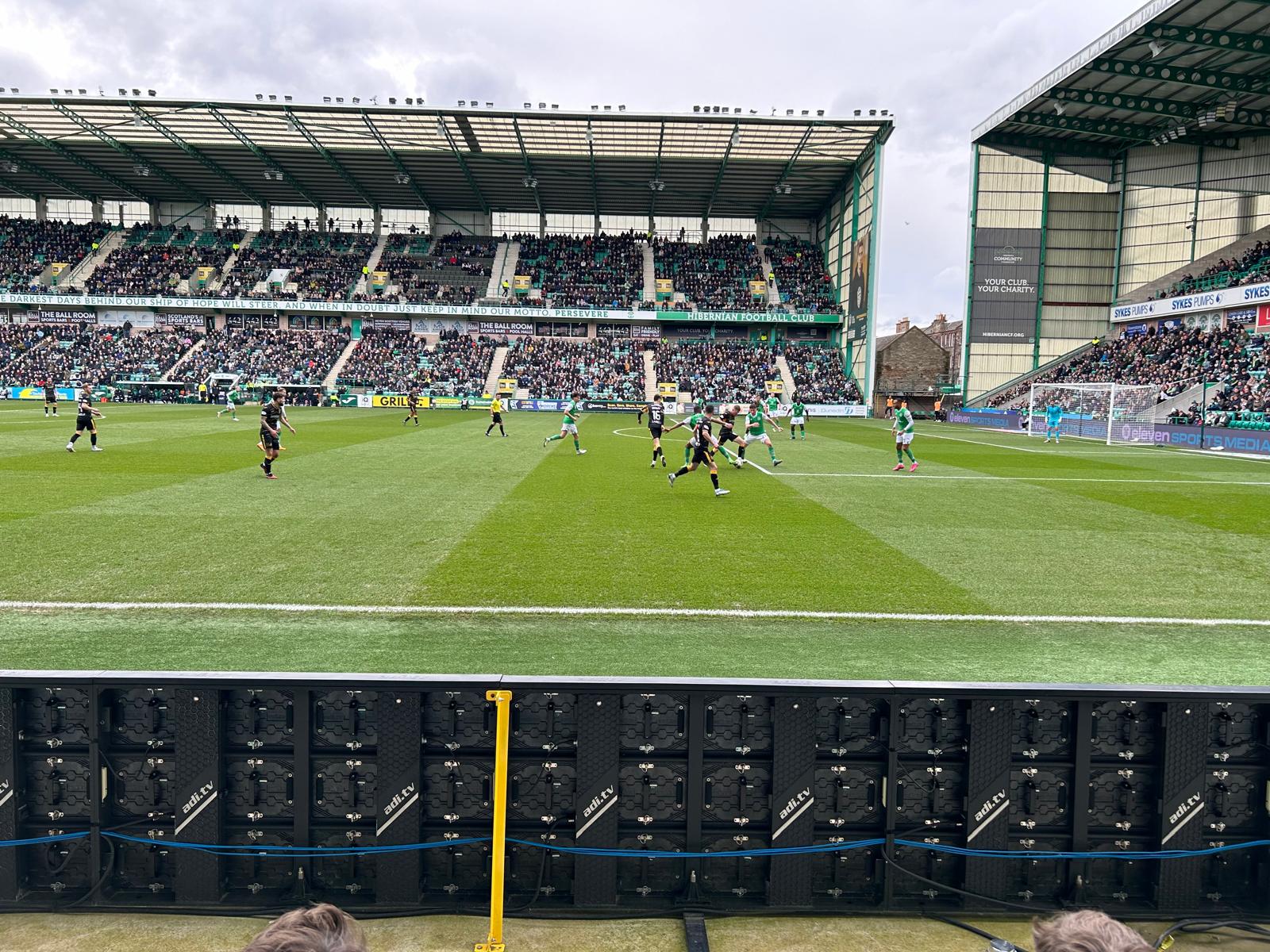 Wedstrijddag op Easter Road met spelers in actie en volle tribunes