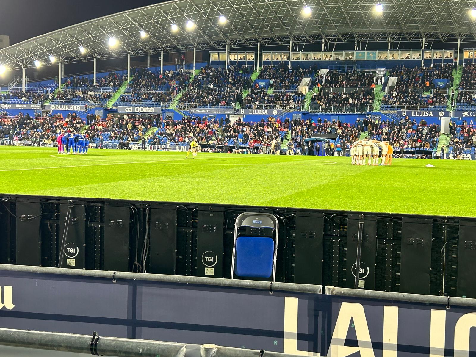 Spelers vormen een huddle op het veld van het Coliseum vlak voor de aftrap
