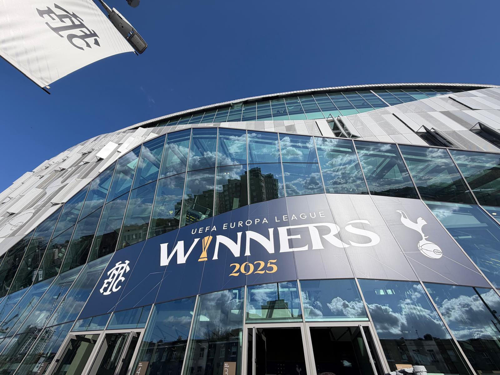 De buitenzijde van het Tottenham Hotspur Stadium met UEFA Europa League Winners 2025 banner